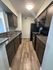 Modern galley kitchen with sleek granite countertops, wood cabinetry, and stainless steel appliances, perfect for culinary enthusiasts.