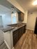 Modern kitchen featuring elegant granite countertops and dark wood cabinetry, complemented by sleek stainless steel appliances and rich wooden flooring.