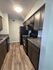 Charming apartment kitchen with modern appliances, elegant countertops, and warm wood cabinetry.
