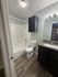 Modern bathroom with elegant wood-look flooring, stylish granite countertop, and bright lighting.