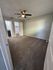 Inviting bedroom with plush carpeting, modern ceiling fan, and adjoining walk-in closet and bathroom.