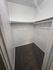 Spacious walk-in closet with neatly installed shelf and plush carpet flooring, perfect for storage and organization.