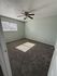 Bright and airy bedroom with plush carpet and modern ceiling fan, perfect for cozy living.