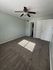 Bright and inviting bedroom with modern ceiling fan, plush carpet, and ample natural light.