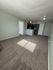 Bright and inviting living space with plush carpeting and modern recessed lighting, leading into a cozy kitchen with stylish cabinetry.