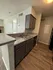 Modern kitchen with sleek countertops, double sink, and stylish cabinetry, perfect for culinary enthusiasts.