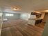 Inviting apartment interior featuring open-concept layout with cozy carpeted living area, modern wood flooring, and functional kitchen.
