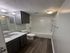 Modern bathroom with elegant dark wood cabinetry, spacious vanity, and stylish fixtures.