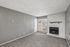 Inviting living room with cozy fireplace, modern gray walls, and abundant natural light streaming through large windows.