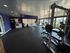 Modern fitness center featuring state-of-the-art gym equipment, vibrant blue walls, and expansive windows offering natural light.