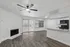 Bright open-concept living space with elegant hardwood floors, contemporary ceiling fan, cozy fireplace, and a stylish kitchen featuring granite countertops and modern appliances.
