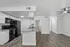Modern kitchen with sleek black appliances, granite countertops, and elegant wood flooring in a spacious, open-concept layout.