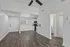 Bright open-concept living area with modern kitchen, featuring sleek white cabinetry and elegant hardwood floors.
