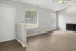 Bright and airy living room with large windows, sleek wood flooring, and a cozy fireplace, ideal for relaxing and entertaining.