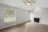 Bright and inviting living room with elegant wood flooring, large windows for natural light, and a cozy fireplace, perfect for relaxation and entertaining.