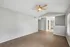 Bright and spacious living area with sleek hardwood floors and modern ceiling fan, featuring plenty of natural light and a neutral color palette.