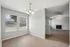 Bright open-concept space featuring wood floors, large windows with natural light, and a cozy living room with a modern ceiling fan and fireplace.