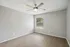 Bright bedroom with elegant wood flooring, neutral wall colors, and a modern ceiling fan, perfect for a cozy retreat.