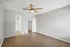 Charming bedroom with sleek wood flooring, spacious closet, and a modern ceiling fan offering comfort and style.