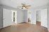 Bright, spacious room with modern laminate flooring, ceiling fan, and access to bathroom and closet.