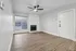 Modern living room with sleek wood flooring, a cozy fireplace, and large windows offering ample natural light.