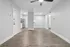 Modern apartment interior showcasing sleek hardwood floors, bright white walls, and a contemporary kitchen with stainless steel appliances.