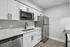 Modern kitchen with sleek white cabinetry, stainless steel appliances, and elegant countertops.