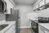 Modern kitchen with sleek white cabinetry, stainless steel appliances, and elegant countertops offering a sophisticated cooking space.