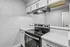 Modern kitchen featuring sleek white cabinetry, stainless steel oven, and elegant countertops in a compact, stylish design.