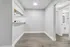 Bright and inviting hallway leading to modern kitchen with sleek fixtures and abundant natural light.