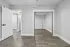 Modern bedroom with sleek mirrored closet doors and elegant wood flooring, offering a clean and welcoming space.