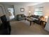 Long Pond Village Apartments, interior, living room, carpeted, natural light, gray couch and love seat, coffee table, end tables, lamp, large window, tv and stand, bedroom doorway