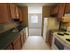 Long Pond Village Apartments, interior, galley kitchen, white appliances, refrigerator, stove/oven, tan cabinets, green counters, tiled floor, view to dining room, window