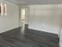 Inviting living area with sleek gray flooring, modern white walls, and ample natural light.
