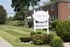Charming red-brick Adams Park Apartments with lush green landscaping and welcoming atmosphere.