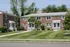 Charming red brick apartments with well-manicured lawns and inviting porches, perfect for comfortable living and modern convenience.