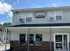 Charming two-story laundromat with red-brick facade, set against a clear blue sky, offering convenient laundry services at Canfield Apartments in Gansevoort, NY.