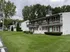 Charming two-story apartment complex with wooden railings, nestled in lush green surroundings, offering serene living spaces at Halfmoon Garden Apartments in Clifton Park, NY.