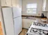 Bright, modern kitchen with sleek white appliances, polished countertops, and ample cabinet space, perfect for culinary adventures at Adams Park Apartments in Albany, NY.