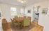 Inviting dining area with elegant wooden furniture and view into a cozy kitchen, creating a warm, stylish atmosphere at Adams Park Apartments in Albany, NY.