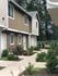 Inviting duplex with garden paths and lush greenery, perfect for family living.