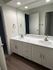 Sleek bathroom featuring a dual sink vanity with white cabinetry and modern fixtures.