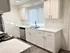 Bright, modern kitchen with elegant white cabinetry, marble countertops, and stainless steel appliances.