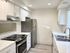 Contemporary kitchen with stainless steel appliances and white cabinetry, featuring a spacious countertop.