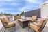 Urban rooftop terrace with plush seating and city skyline view.