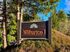 Inviting entrance sign for Wilburton I Apartments, surrounded by lush greenery and vibrant trees.