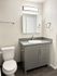 Modern bathroom with sleek gray vanity, spacious countertop, and contemporary fixtures.
