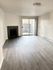 Bright and airy living room with elegant wood flooring, modern fireplace, and sliding glass doors leading to a private balcony.