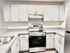 Modern kitchen with sleek white cabinetry, stainless steel appliances, and elegant countertops.
