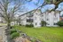 Charming apartment complex surrounded by lush greenery, featuring modern balconies and a beautifully maintained exterior.